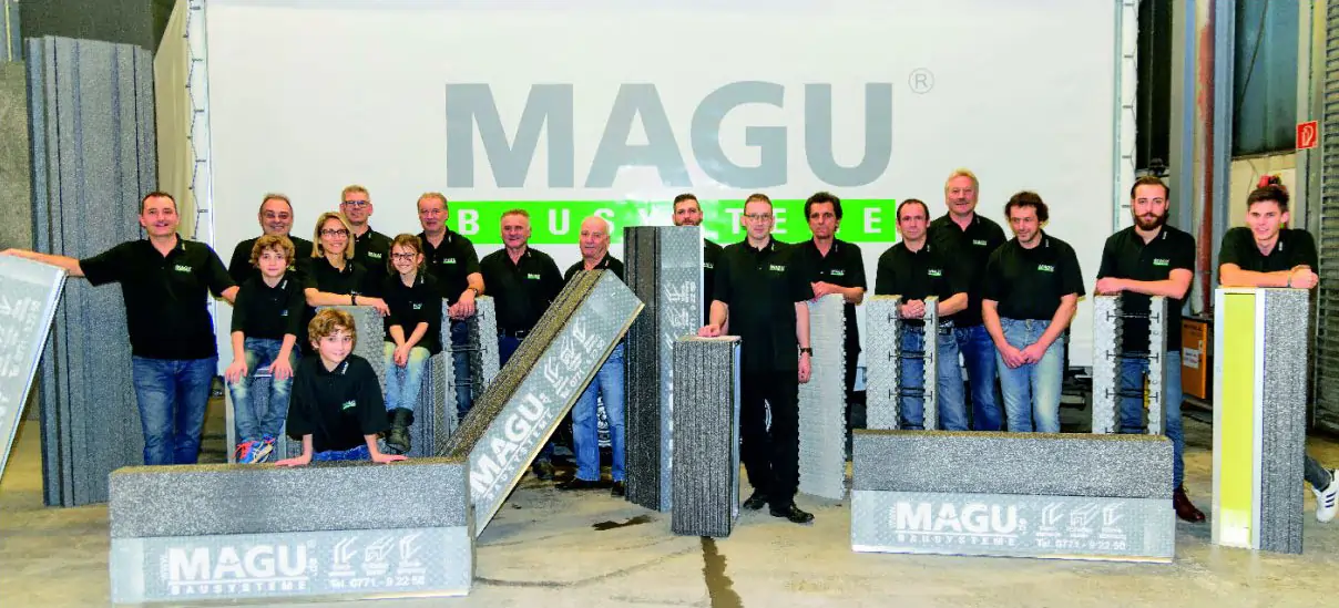 Gruppenfoto des MAGU-Teams in Hüfingen mit verschiedenen MAGU-Bauelementen, die stolz vor einem MAGU-Banner präsentiert werden.