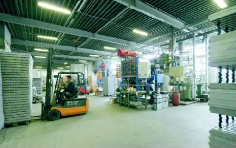 Produktionshalle von MAGU mit moderner Fertigungstechnik. Ein Gabelstapler transportiert Material, während Maschinen den Produktionsprozess steuern.