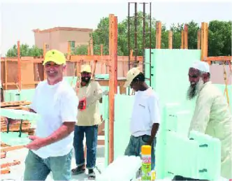 Baustellenbesichtigung in Dubai mit mehreren Arbeitern, darunter Vorführmeister Franz, die mit grünen MAGU Schalungselementen arbeiten.